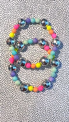 a multicolored beaded bracelet on a polka dot background