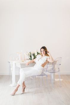 a woman in white sitting at a table