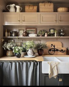 a kitchen filled with lots of pots and pans on top of a wooden counter