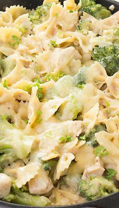 a skillet filled with pasta and broccoli on top of a red checkered table cloth