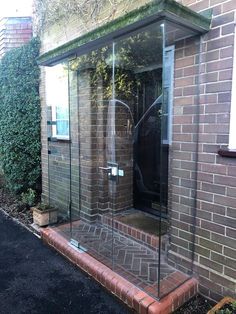 a brick building with a glass door on the front and side walk up to it