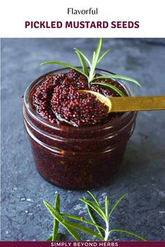 a jar filled with pickled mustard sitting on top of a table next to rosemary sprigs