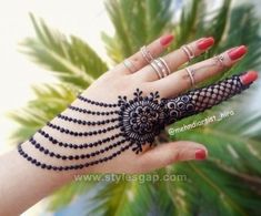 a woman's hand with hennap and rings on her palm tree branch