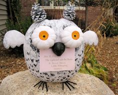 an owl statue is sitting on top of a rock