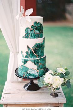 a white and green wedding cake on a table