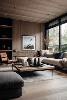 a living room filled with lots of furniture next to a large window and wooden floor