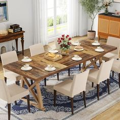 a dining room table and chairs in front of a window with an area rug on the floor