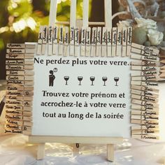 a sign that is on top of a wooden easel with wine glasses in it