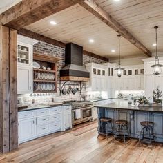 a large kitchen with white cabinets and wood flooring on the walls is pictured in this image