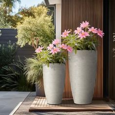 two large white vases with pink flowers in them