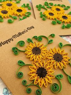 two greeting cards decorated with sunflowers on brown paper and green spiraly pins