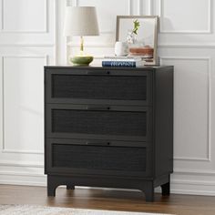 a night stand with two drawers and a lamp on it in a white living room