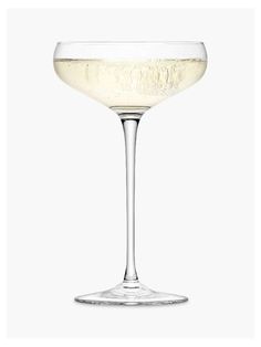 a glass filled with white wine on top of a table