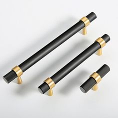 three black and gold handlebars on a white background