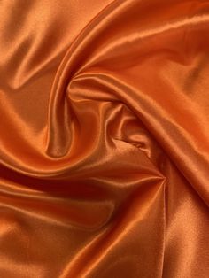 "60\" wide luxurious orange charmeuse satin fabric is a beautiful lightweight soft and smooth with a silk like appearance and feel, drapes nicely and made with 100% polyester fibers. Great for party decor, backdrops, blouses, apparel, lingerie, lining, chair sashes, curtains, tablecloths, linens, overlays, and much more. Sold by the yard continuous up to the length of the roll. For instance an order of 1 yard (Qty=1) is 60\" x 36''. Order of 3 yards (Qty=3) is 60\" x 108''. Color can vary by dye Charmeuse Fabric, Orange Satin, Chair Sashes, Orange You Glad, Orange Aesthetic, Burnt Orange Color, Burlap Fabric, Luxury Aesthetic, Muslin Fabric