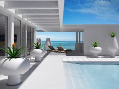 an indoor swimming pool next to the ocean with lounge chairs and flowers in vases