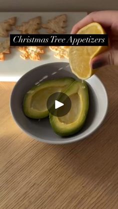 someone is peeling an avocado in a bowl with crackers on the side