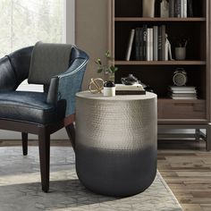 a living room with a chair, bookcase and table in it's center