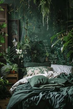 a bed with green sheets and plants hanging from the ceiling in front of it, surrounded by greenery