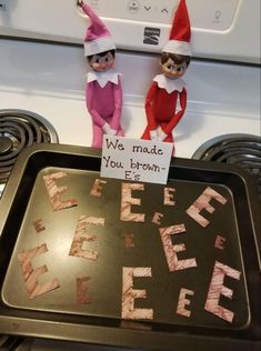 two elfs sitting on top of a baking pan with the words we made you brown