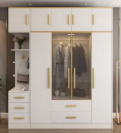 a white and gold closet with clothes hanging on the doors, drawers, and shelves