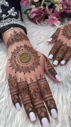 two hands with henna designs on them, one is white and the other is brown