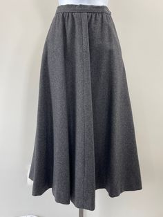 This fully-lined wool full skirt has an a-line silhouette and two side pockets.  A one button closure on left side, with hook & eye.  Decade:  1970s Fabric:  100% Wool | Lining- 100% Acetate Size: Vintage 6  Condition:  Excellent Brand:  Ralph Lauren Measurements:  Waist (Laid Flat)- 12" |. Hips (Laid Flat)- 16". |. Length- 31" Retro A-line Winter Skirt, Chic A-line Wool Bottoms, Chic Wool A-line Skirt, Formal Spring Wool Skirt, Formal Wool Skirt For Spring, Elegant Wool Full Skirt, Spring Formal Wool Skirt, Spring A-line Wool Skirt, A-line Wool Bottoms For Work