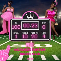 two women in pink dresses standing next to a scoreboard