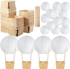 white paper lanterns and wooden sticks are arranged on the table with other items to make it look like they have been made out of wood