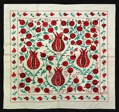 an embroidered cloth with red flowers and leaves