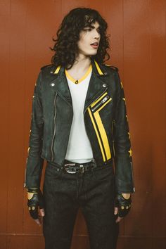 a woman wearing a green and yellow leather jacket