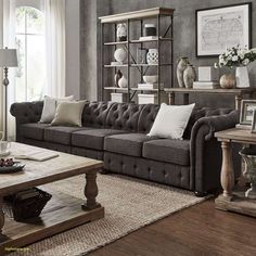 a living room with gray couches and white pillows on top of the sofas