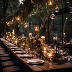 a long table is set with candles, plates and place settings for an elegant dinner