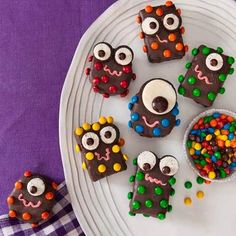 a plate topped with cookies covered in chocolate and sprinkles on top of a purple table cloth