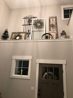 there are pictures on top of the shelves above the door and windows in this house