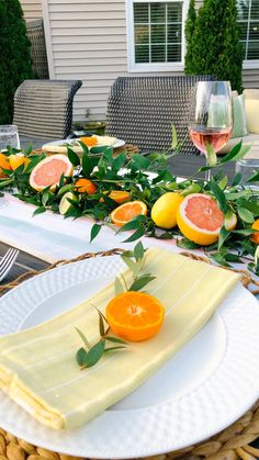 the table is set with grapefruits and oranges