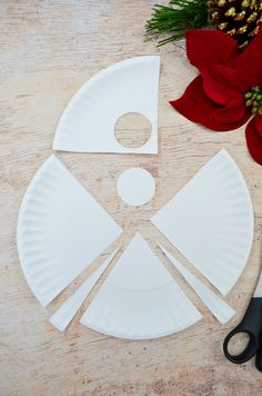 the paper plate is cut out to look like a face with scissors and poinsettis