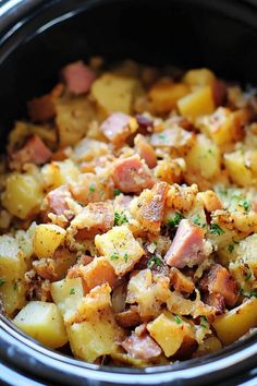 a crock pot filled with potatoes, ham and other toppings on top of it