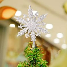 a snowflake ornament on top of a christmas tree