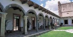 an old building with arches and columns on the outside, along with potted plants