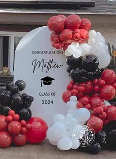 graduation balloons are arranged in the shape of a graduate's cap on a grave