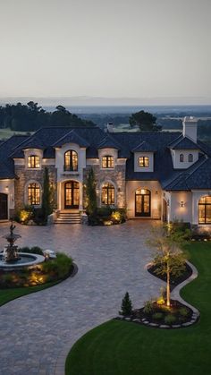 a large house with lots of windows and lights on it's front lawn area