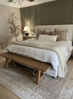 a bed room with a neatly made bed and a wooden bench on the floor next to it