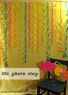 a chair sitting in front of a yellow backdrop with streamers