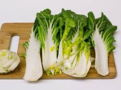 some lettuce is sitting on a cutting board