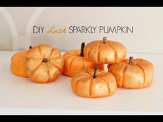 small orange pumpkins sitting on top of a white table next to each other and the words diy dish sparkly pumpkin