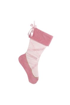 a pink and white christmas stocking hanging from the side on a string with ribbon