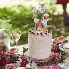 a wedding cake with flowers and candles on the top is surrounded by other desserts