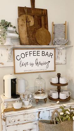 a coffee bar with cups and mugs sitting on top of an old white cabinet