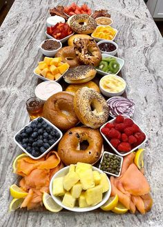 a long table topped with lots of different types of donuts and other food items